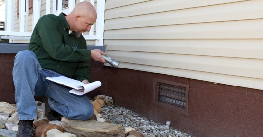 man inspecting home foundation